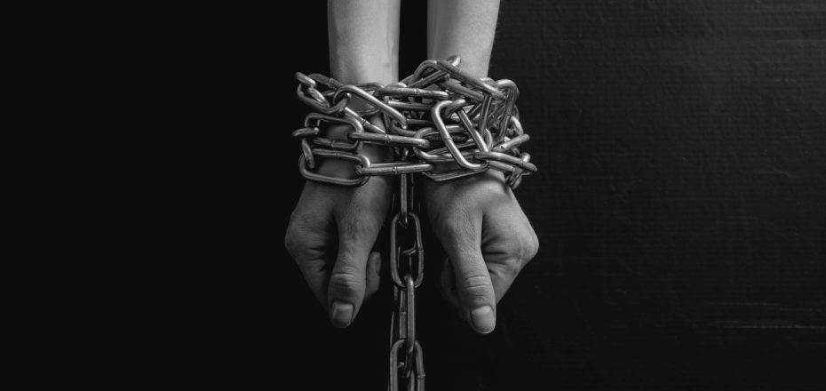 Black and white minimalistic image. women's hands chained close-up on a black background, toned to a retro film.